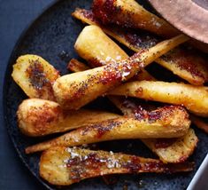 french fries covered in ketchup on a black plate