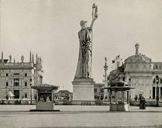 an old black and white photo of a statue in the middle of a city square