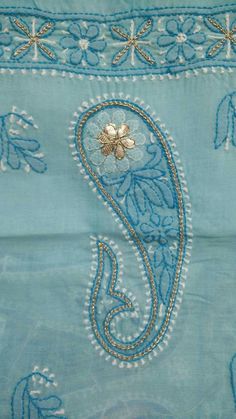 an embroidered blue cloth with gold and white designs on it's side, showing the initial letter s