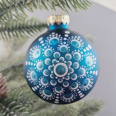 a blue ornament hanging from a christmas tree