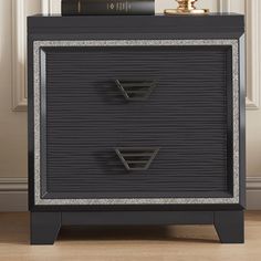 a black and silver nightstand with books on top