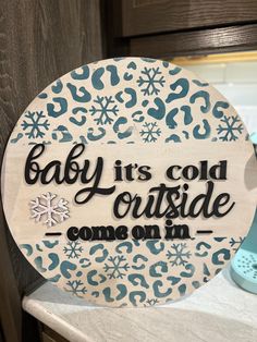 a sign that says baby it's cold outside come on in snowflakes