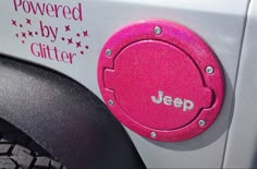 a pink jeep emblem on the side of a white vehicle with stars and words painted on it