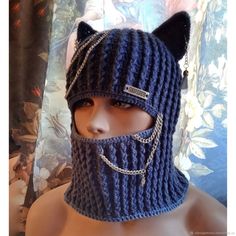 a mannequin wearing a knitted mask with chains on it's face