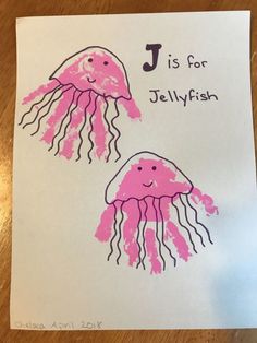 two pink jellyfish handprints on white paper with the letter j is for jellyfish