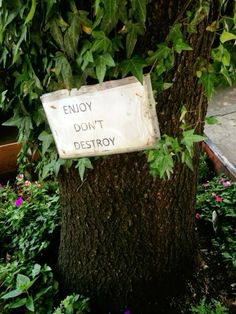 a sign on a tree that says enjoy don't destroy