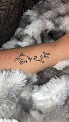 a woman's arm with a tattoo that says, birth and leaves on it