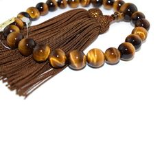 Tiger Eye Japanese Traditional Juzu Buddhist Prayer beads Characteristics of the product Material : Tiger Eye, Silk cord Head bead : about 12mm Main bead : about 8mm Diameter : about 80mm (not stretch) Handmade in Kyoto, JAPAN About juzu One-handed Prayer beads, it can be used by any Buddhist school. In Japan, Buddhists use Prayer beads (Juzu, Nenju). Kyoto is a famous producing center of Prayer beads. Prayer beads are a traditional tool used to count the number of times a mantra is recited, the breaths one takes while meditating, the prostrations, or the repetitions of a buddha's name. About tiger eye Kwown as the gem of courage, the Tiger’s Eye combines properties that promote vitality, help you regain personal power and prevail over emotional blocks. Its bold, encouraging energy is also Brown Jewelry With 8mm Round Beads, Adjustable 8mm Beads For Jewelry Making, Adjustable Polished Beads Rosary For Meditation, Brown Round Beads For Jewelry Making, Adjustable Rosary With Polished Beads For Meditation, Brown Healing Rosary With Round Beads, Healing Brown Rosary With Round Beads, Adjustable Round Spiritual Rosary, Adjustable Spiritual Rosary