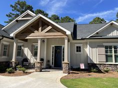 a white house with gray shutters and stone pillars