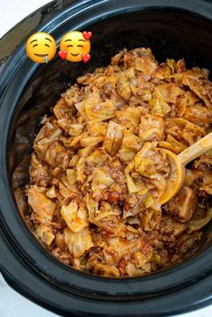 a slow cooker filled with cabbage and meat next to an emoticive smiley face sticker