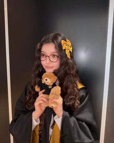 a girl in graduation gown holding a teddy bear