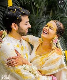 a man and woman covered in yellow paint are smiling at each other as they pose for the camera