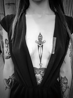 a woman's chest with a tattoo on it and a knife in the middle