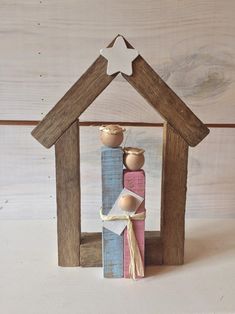 a nativity scene made out of wood and painted pink, blue, yellow and red