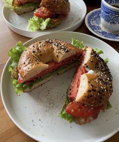 two plates with sandwiches on them sitting on a table