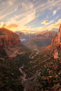 the sun is setting over some mountains and canyons in the distance, with a river running between them