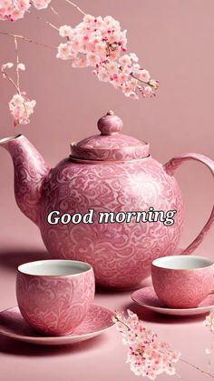 a pink tea set sitting on top of a table next to a cup and saucer