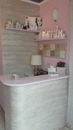 a pink and white bathroom with shelves on the wall above the bathtub that is covered in personal care items