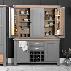 a kitchen with grey cabinets and wooden shelves