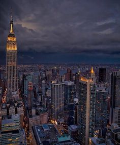 an aerial view of the empire building in new york city at night with dark clouds