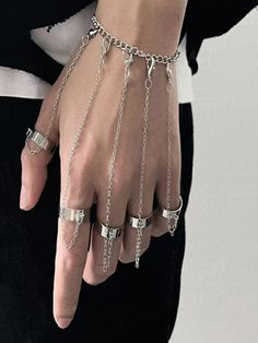 a person wearing chains and rings on their hands, with the word sinlan written in silver