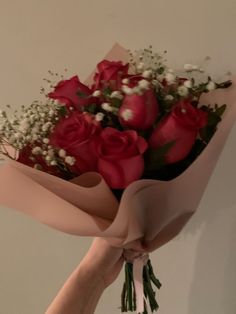 someone holding a bouquet of roses in their hand