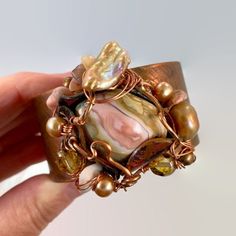 Pink And Shades Of Soft Browns And Beige.... Starting With A Copper Cuff Bracelet That I Have Hammered And Heated For An Amazing Color... I Then Chose The Large Jasper Stone That Is The Centerpiece Of This Bracelet. I Love The Swirling Shades Of Pink And Cream. I Encased It In A Freeform, Forged Copper Bezel With A Unique Organic Shape To It. I Have Given It An Artistic And Organic Wire Wrap . For Additional Accents I Have Used Beads In Stone, Glass And Pearls To Enhance The Shades Of The Stone. Fusion Style Cuff Bracelet Gift, Handmade Bohemian Bangle As Gift, Handmade Artisan Metal Bangle, Handmade Metal Artisan Bangle, Fusion Style Metal Jewelry For Gifts, Fusion Style Bracelet Jewelry As Gift, Fusion Style Bracelet Jewelry For Gifts, Fusion Style Bracelet Jewelry Gift, Fusion Style Jewelry Bracelet For Gifts