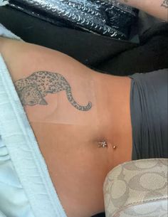 a woman's stomach with a leopard tattoo on the side and an under belly