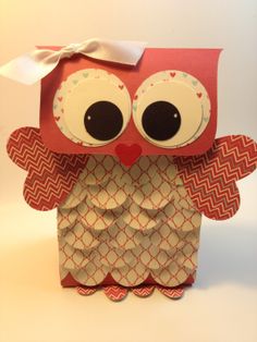 an origami owl with big eyes and a bow on its head