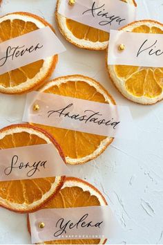 orange slices with name tags on them sitting on a table