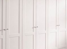 a white closet with many doors and drawers