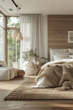 a large bed sitting in a bedroom next to a tall glass window on top of a wooden floor