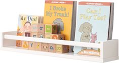 two children's books are sitting on a shelf with blocks in front of them