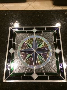 a stained glass window with a star in the center on a black marble countertop