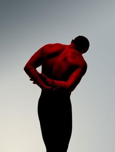 the silhouette of a man with his hands on his hips