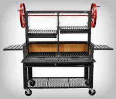 an outdoor bbq grill with wheels and two trays on the side, one being open