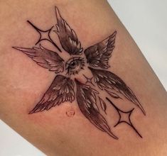 a small tattoo on the leg of a woman with an owl in it's wings