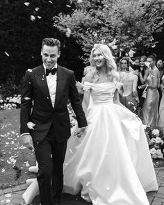 a bride and groom are walking through confetti