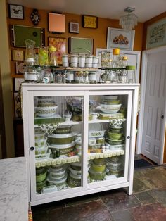 a display case filled with lots of different types of jars and containers on top of glass doors