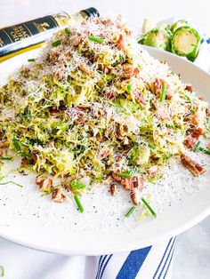 a white plate topped with shaved brussels sprouts and shredded parmesan cheese