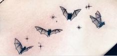 some bats are flying around on the back of a woman's stomach and it looks like they have been inked