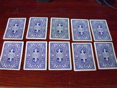 six blue and white playing cards laid out on a wooden table next to a keyboard