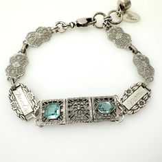 Unique, one-of-a-kind vintage repurposed sterling silver Art Deco era bracelet.  This beauty features an Art Deco section for the centerpiece featuring filigree design with blue stone accents sterling silver metal.  On each side, I've added a sterling silver Forget Me Not link; one that has a light engraved word Grandma and the other is Mom.  The bracelet is finished with Art Deco filigree links.  Adjustable length with swivel lobster claw closure and a dangling vintage rhinestone button accent. Era Bracelet, Vintage Assemblage Jewelry, Repurposed Art, Beauty Features, Vintage Repurposed, Art Deco Bracelet, Assemblage Jewelry, Filigree Design, Silver Art