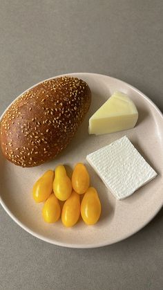 a white plate topped with bread and cheese next to jelly beans on a gray surface