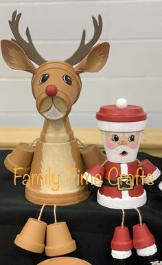 two christmas figurines sitting next to each other on top of a black table