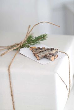 a white present box wrapped in twine and tied with twine, sitting on top of a table