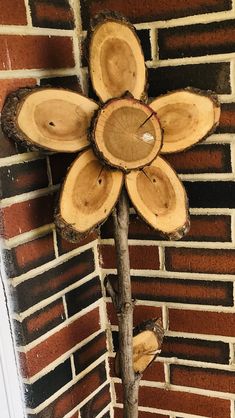 a cross made out of wood sitting on top of a brick wall