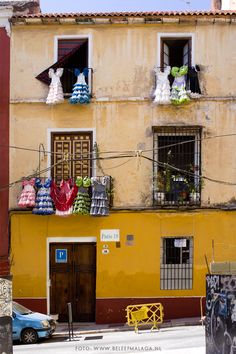 a yellow building with lots of windows and decorations on the balconies above it