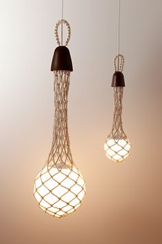 two light bulbs hanging from the ceiling with wire wrapped around them and one bulb is turned on