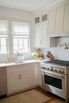 a kitchen with white cabinets and stainless steel appliances